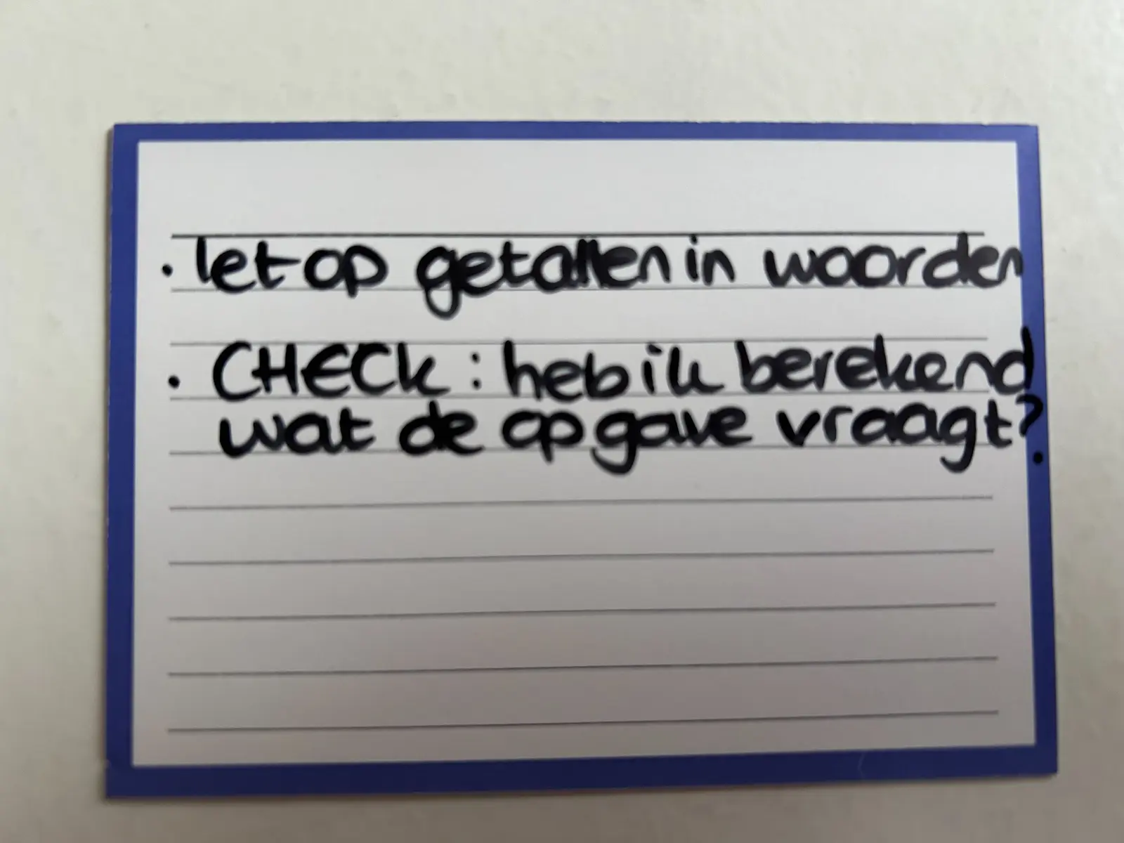 Handgeschreven kaartje met controlevragen over de aanpak van een opgave